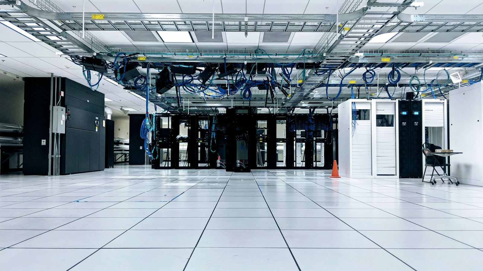 Data hall with aligned server cabinets and overhead cable trays